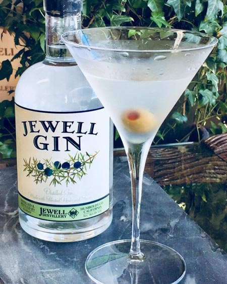 bottle of jewel gin and a martini glass with olive
